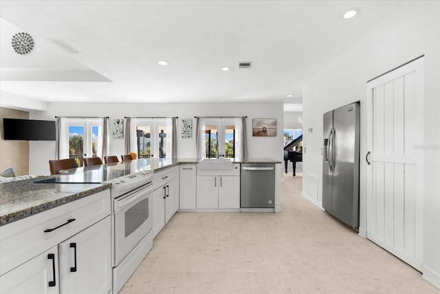 kitchen featuring french doors, white cabinets, stainless steel appliances, and plenty of natural light