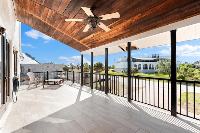 view of patio with ceiling fan and a balcony