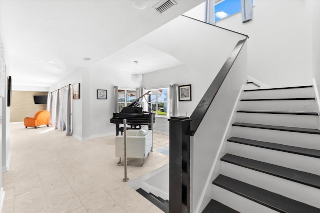 stairway featuring a chandelier