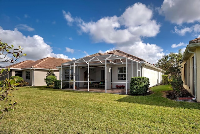 back of house featuring a patio, glass enclosure, and a lawn