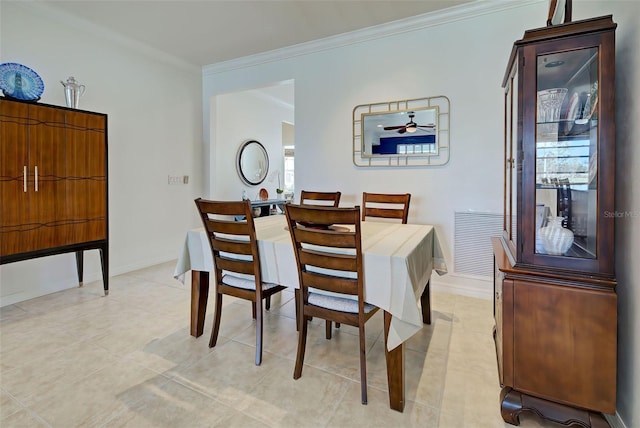 tiled dining area featuring ceiling fan and crown molding