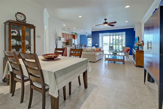 dining area with ceiling fan, crown molding, and light tile patterned flooring