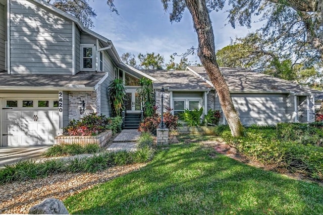 view of front facade featuring a front yard, french doors, and a garage