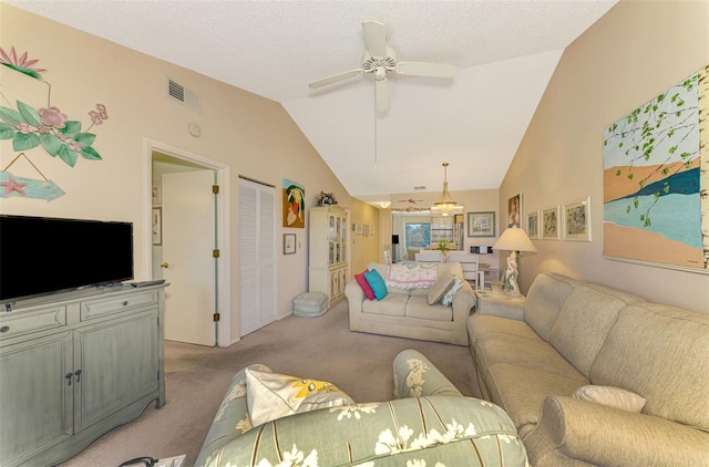 living room featuring a textured ceiling, light colored carpet, vaulted ceiling, and ceiling fan