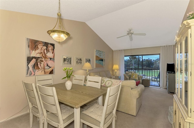 carpeted dining area featuring ceiling fan and lofted ceiling