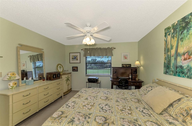 bedroom featuring a textured ceiling, ceiling fan, and light carpet