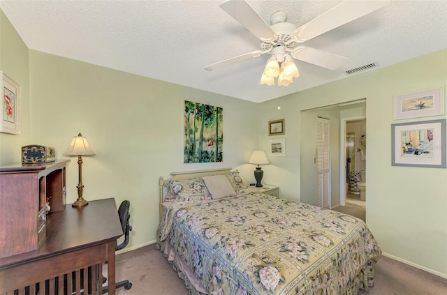 bedroom with ceiling fan, a closet, light carpet, and a textured ceiling