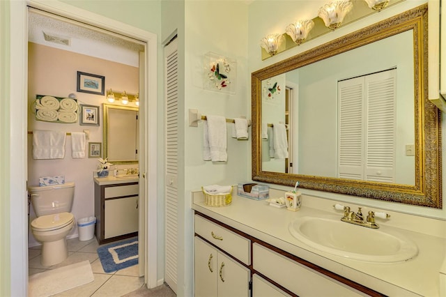 bathroom featuring tile patterned flooring, vanity, and toilet