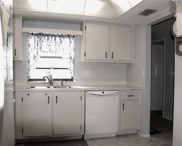 kitchen featuring dishwasher, light tile patterned floors, white cabinets, and sink