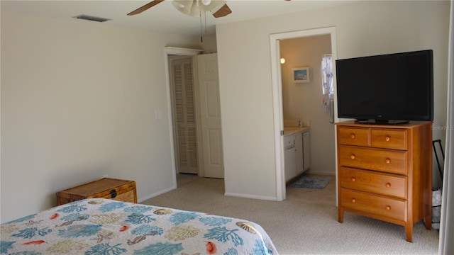 bedroom featuring ensuite bathroom, ceiling fan, and light carpet