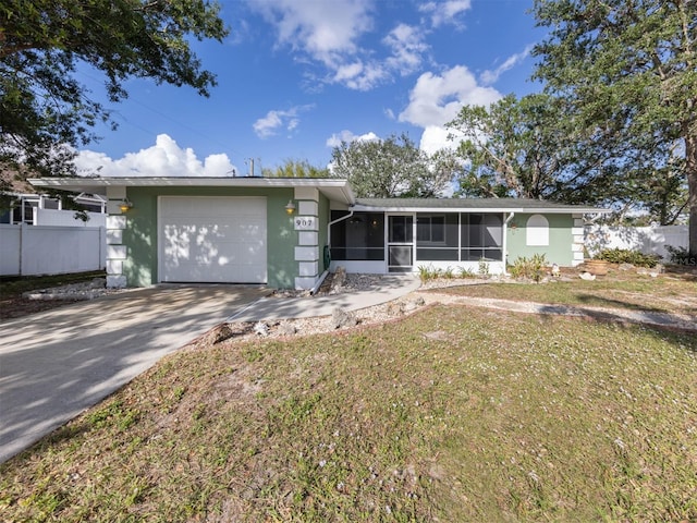 ranch-style house with a sunroom, a garage, and a front yard