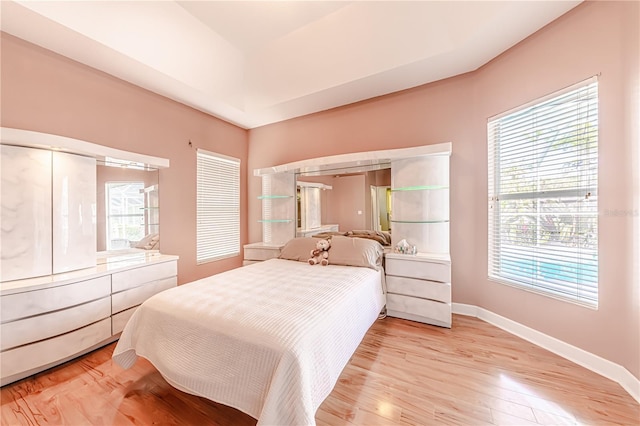 bedroom with multiple windows and light hardwood / wood-style flooring