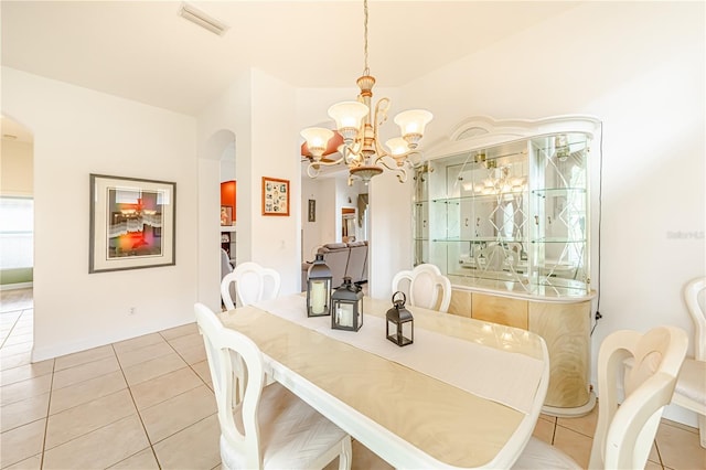 tiled dining space with a chandelier