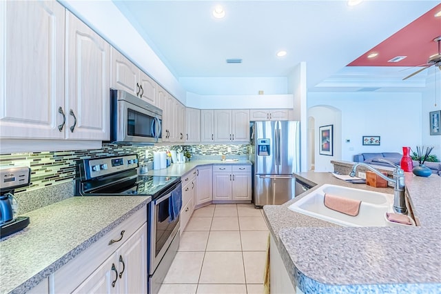 kitchen featuring light tile patterned flooring, appliances with stainless steel finishes, sink, and backsplash