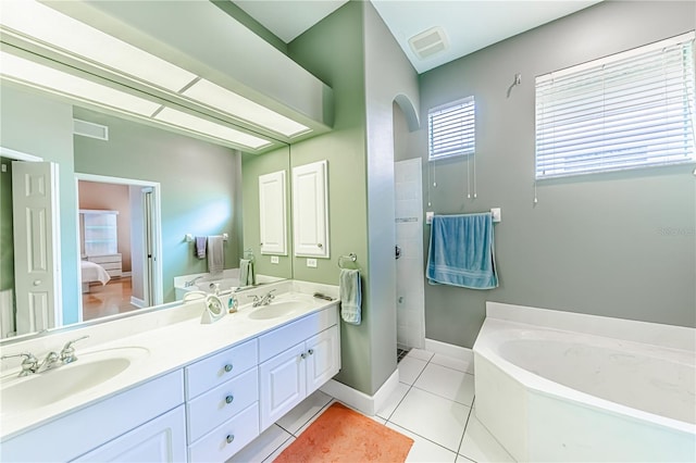 bathroom with vanity, tile patterned floors, and a tub to relax in