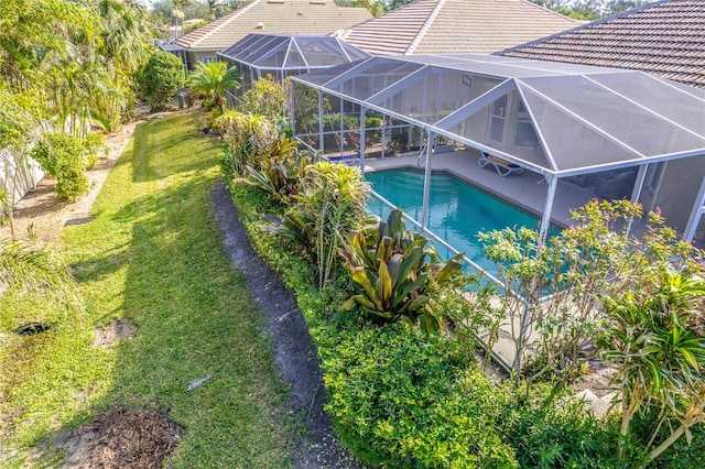 view of swimming pool with a lanai and a yard