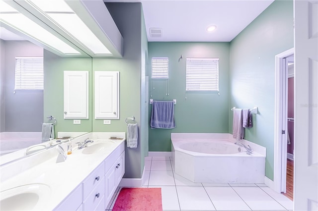 bathroom featuring tile patterned flooring, vanity, a bathtub, and a wealth of natural light