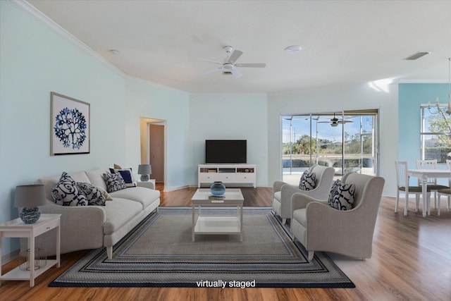 living room featuring an inviting chandelier, ornamental molding, and hardwood / wood-style floors