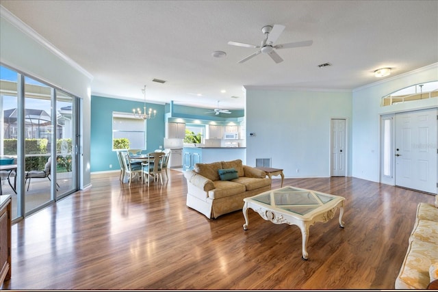 living room with ceiling fan with notable chandelier, ornamental molding, and hardwood / wood-style floors