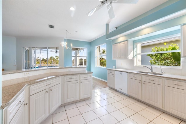 kitchen featuring light stone countertops, dishwasher, hanging light fixtures, light tile patterned flooring, and sink