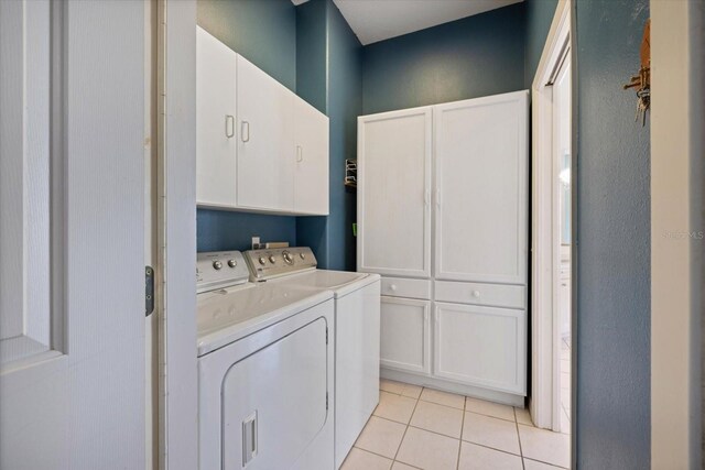 laundry area with independent washer and dryer, cabinets, and light tile patterned floors