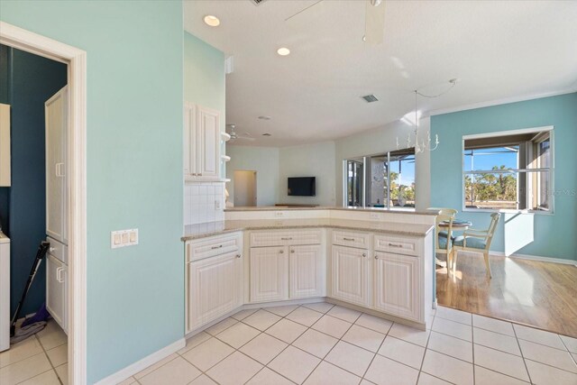 kitchen with tasteful backsplash, light tile patterned floors, and kitchen peninsula