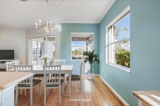 dining area featuring a notable chandelier, light wood-type flooring, and crown molding