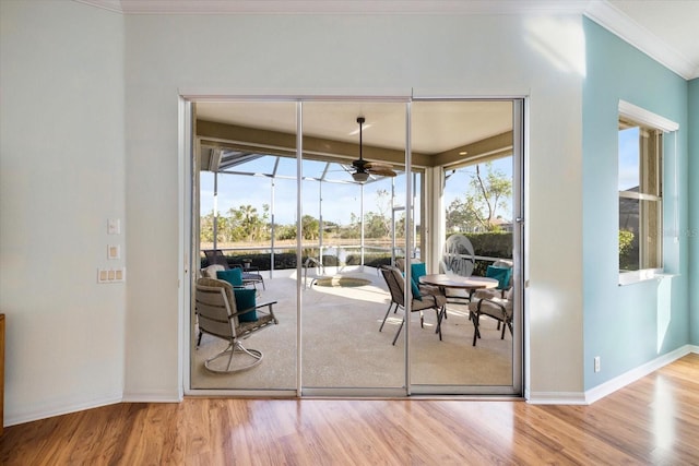 entryway with ceiling fan, crown molding, and wood-type flooring