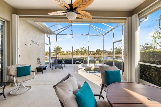 sunroom with ceiling fan and a water view