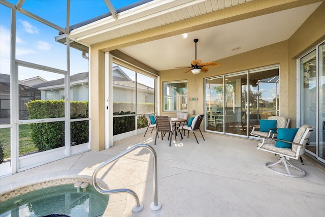 sunroom / solarium featuring ceiling fan and a hot tub