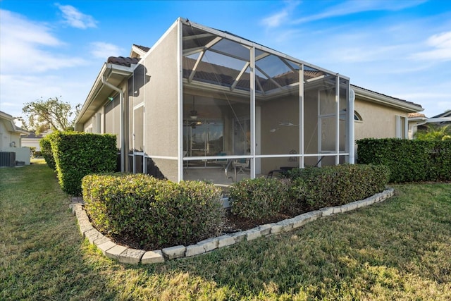 view of side of property with a lanai, a patio area, and a lawn