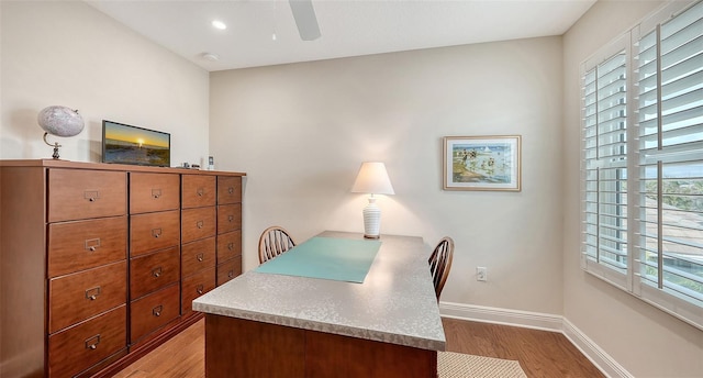 office featuring light wood-type flooring, ceiling fan, and a healthy amount of sunlight