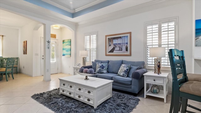 living room featuring light tile patterned floors, crown molding, and a tray ceiling