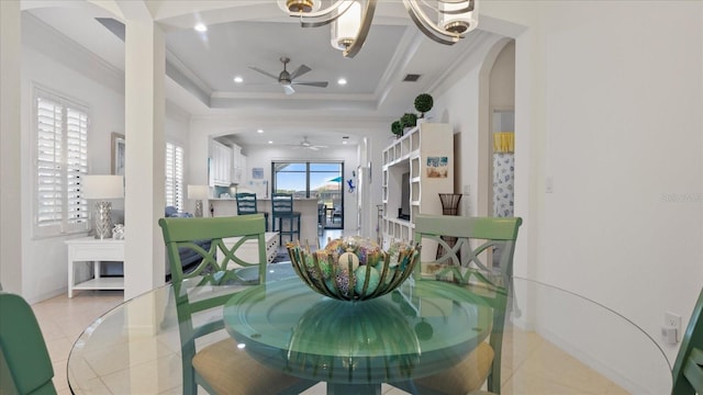 dining space featuring light tile patterned floors, a tray ceiling, ceiling fan, and ornamental molding