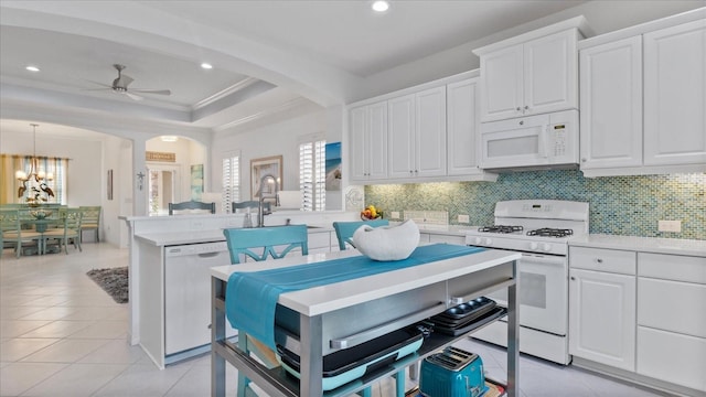 kitchen featuring white cabinetry, hanging light fixtures, white appliances, light tile patterned floors, and ceiling fan with notable chandelier