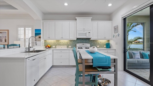 kitchen featuring light tile patterned floors, white appliances, white cabinetry, and sink