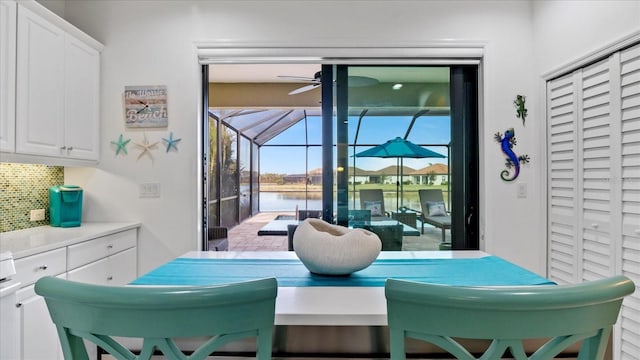 interior space with a water view and ceiling fan