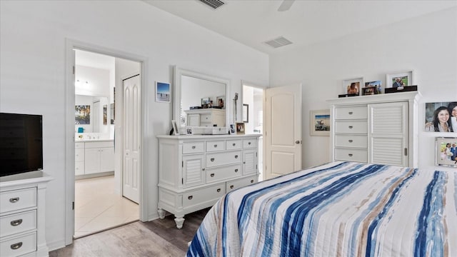 bedroom featuring light tile patterned floors, connected bathroom, and ceiling fan