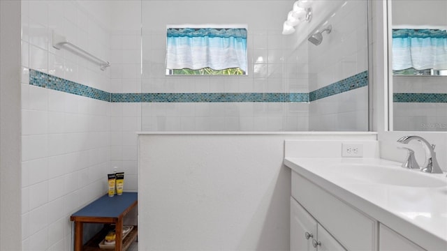 bathroom featuring tiled shower and vanity