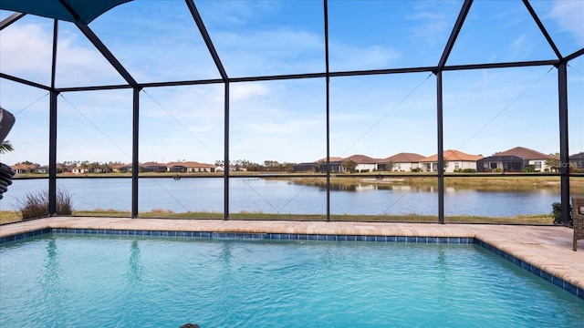 view of pool featuring a water view and glass enclosure