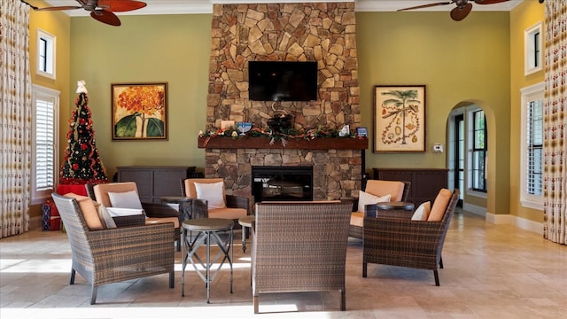 living room with a fireplace, ceiling fan, and ornamental molding