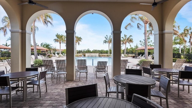 view of patio / terrace with ceiling fan, a water view, and a community pool