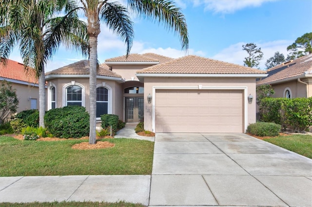 mediterranean / spanish-style house with a front yard and a garage