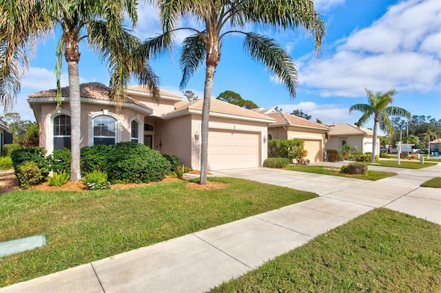 mediterranean / spanish-style house featuring a garage and a front yard