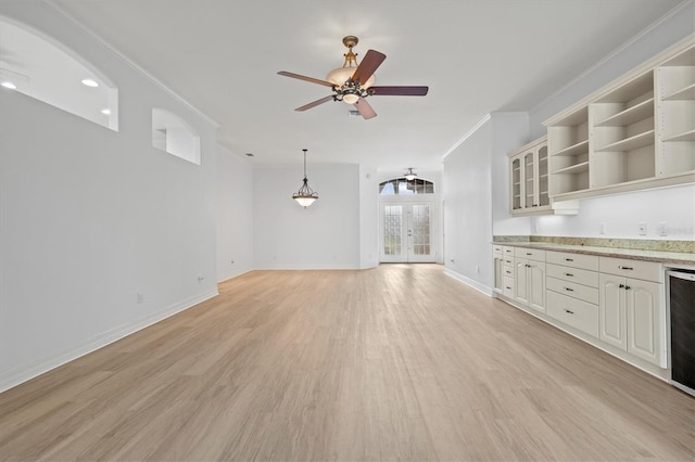 unfurnished living room with ceiling fan, ornamental molding, french doors, and light hardwood / wood-style flooring