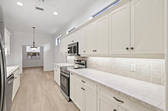 kitchen with decorative backsplash, ceiling fan, white cabinetry, and stainless steel appliances