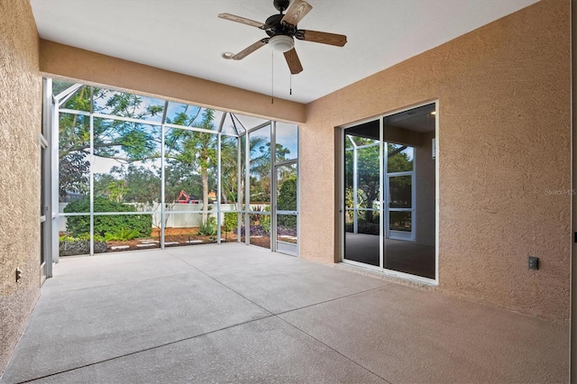 unfurnished sunroom featuring ceiling fan