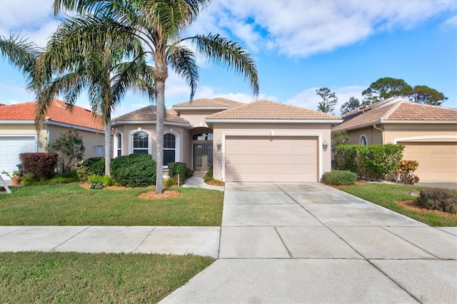 mediterranean / spanish house with a front lawn and a garage