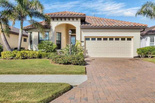 mediterranean / spanish house with a front yard and a garage