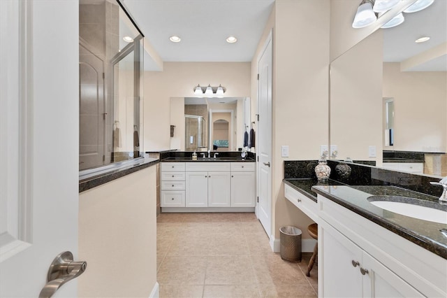 bathroom with tile patterned flooring, vanity, and a shower with shower door